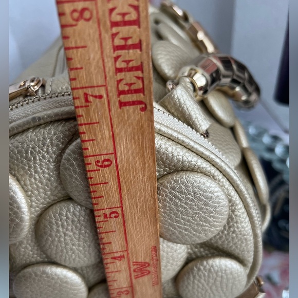 unique design with embossed circular details and a structured, metallic handle. - Picture 11 of 12